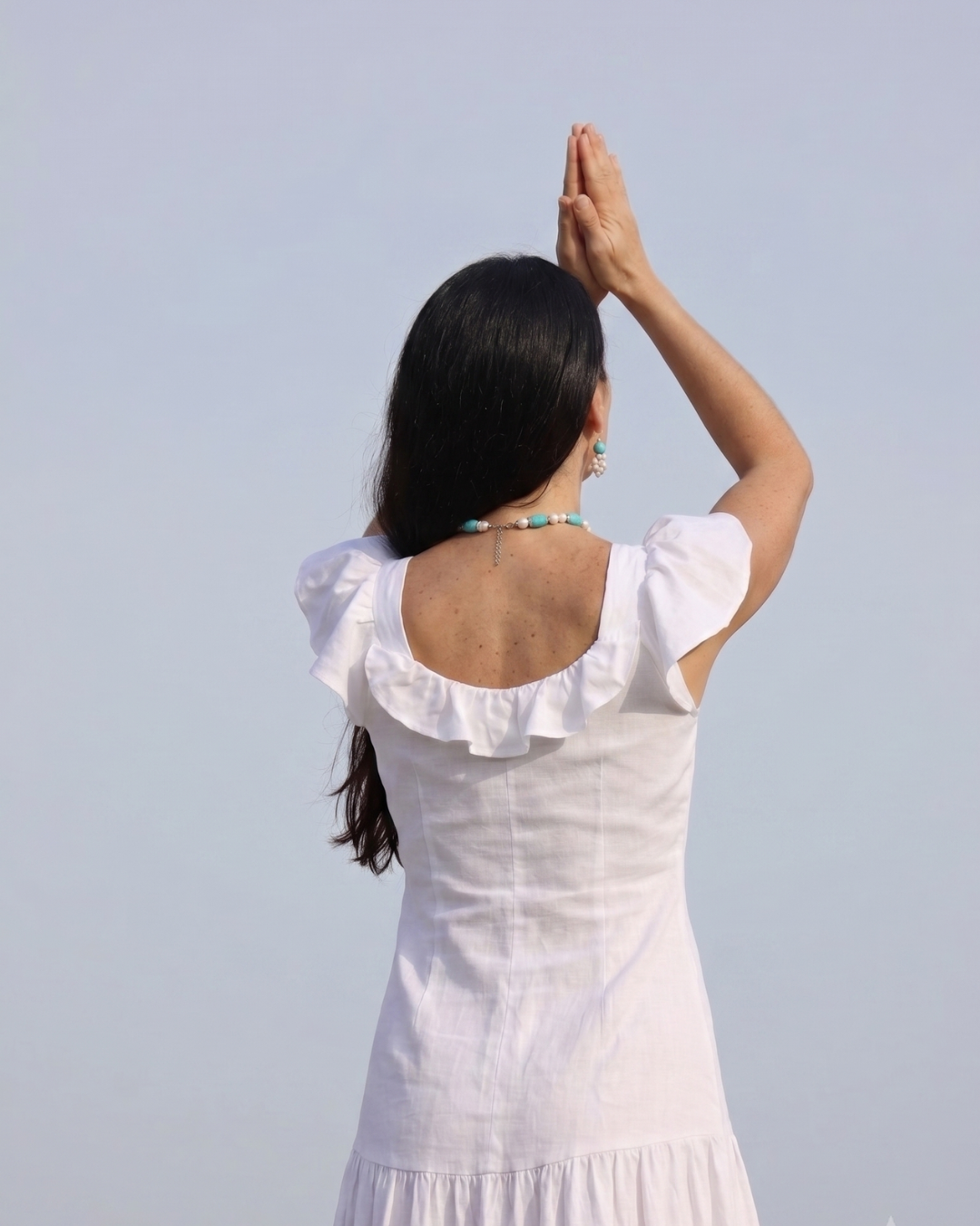 Mujer en vestido blanco con las manos en posición de oración